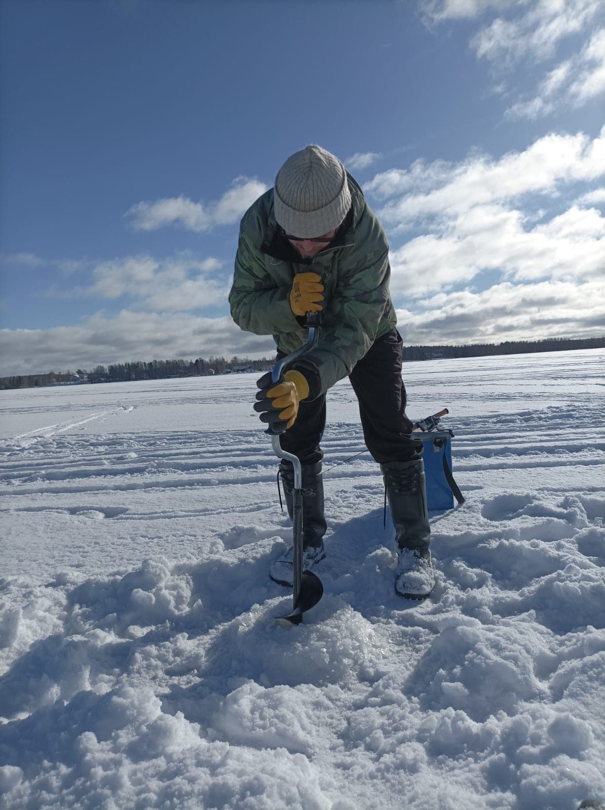 Janne drilling a hole through the ice on a Lapland winter day. On northern waters the ice can grow so thick that the auger needs an extension piece to break through.